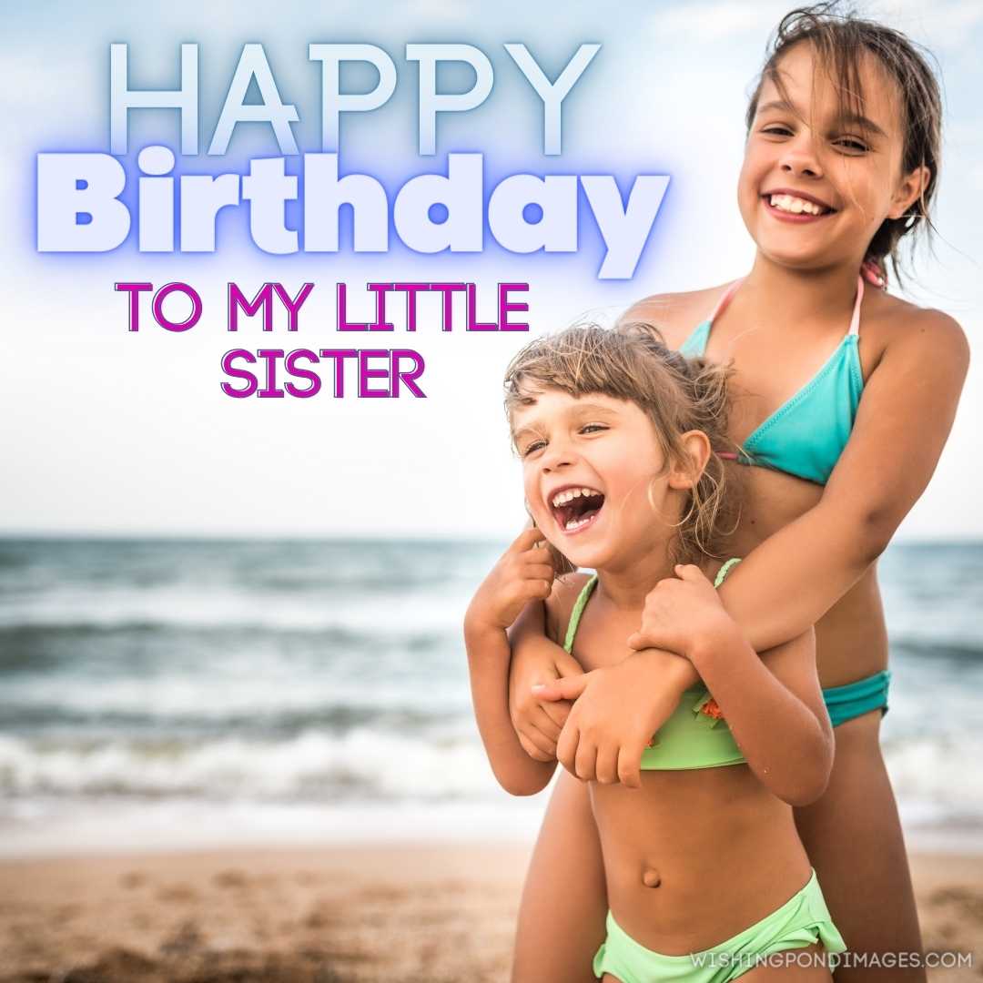 Two cute positive little girls sisters raised their hands up while swimming at sea during the holida